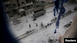 People inspect the damage at a site hit with airstrikes by pro-Syrian government forces in the rebel held Douma neighborhood of Damascus, Syria, Feb. 14, 2016.