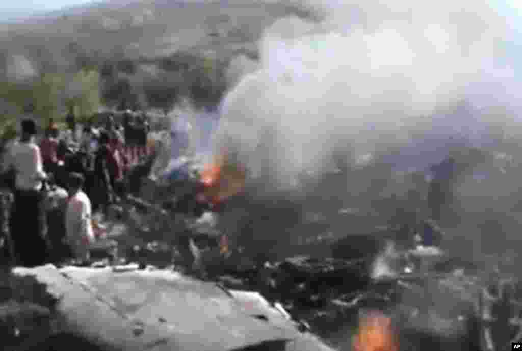 This image taken from video obtained from the Ugarit News shows people near a destroyed plane that was shot down by Free Syrian Army fighters in Aleppo, Syria, November 28, 2012.