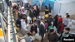 19일 가자지구 남부 칸 유니스에서 팔레스타인 난민들이 물을 배급받고 있다.