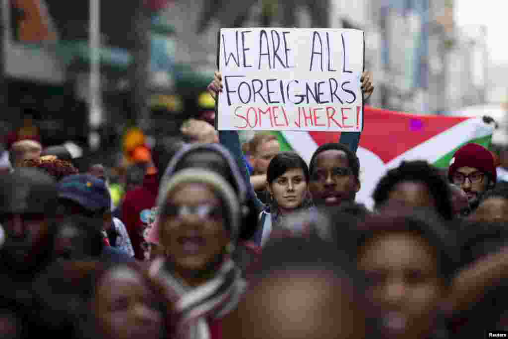 A woman holds up a sign reading "We are all foreigners somewhere!" during a peace march after anti-immigrant violence flared in Durban, April 16, 2015.