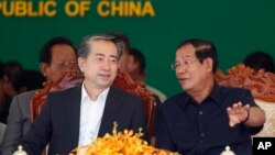 Cambodian Prime Minister Hun Sen, right, talks with Chinese Ambassador to Cambodia Xiong Bo, front left, during an inauguration ceremony of a sky bridge funded by China in Phnom Penh, Cambodia, July 2, 2018. 