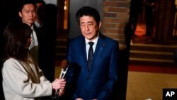 Japan's Prime Minister Shinzo Abe talks to journalists in front of the prime minister's residence in Tokyo, March 24, 2020. 