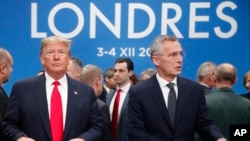 U.S. President Donald Trump and NATO Secretary General Jens Stoltenberg wait to take their seats prior to a NATO leaders meeting at The Grove hotel and resort in Watford, Hertfordshire, England, Dec. 4, 2019. 