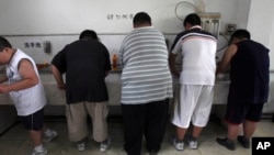 FILE - In this July 24, 2008 file photo, obese patients wash their plates after lunch at the Aimin Fat Reduction Hospital in Tianjin, China. 