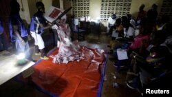 Polling agents start to count the ballots for the Liberian presidential election at a polling station in Monrovia, Liberia, Oct. 10, 2017. 