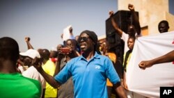 FILE - A man shouts as he and others are seen gathered at the Place de Nation calling for a civilian democratic transition in Ouagadougou, Burkina Faso, Nov. 2, 2014.