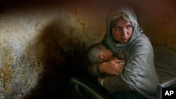 Habiba, who has completed three years of a 10-year prison sentence for murder, holds her daughter Nazanin who was born in jail three years ago but still cannot walk, as they rest in their bunk bed inside Pul-e Charkhi prison in Kabul, Afghanistan. (File P