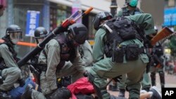 资料照：2020年5月24日，在香港铜锣湾举行的反对国安法的示威活动中，防暴警察拘留了一名抗议者。（美联社）