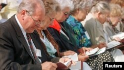 Jehovah's Witnesses read the Bible during a bible study at a international meeting in Berlin's Olympic Stadium July 31. Around 60,000 Jehovah's witnesses from all over the world took part in a three-day convention in Berlin.