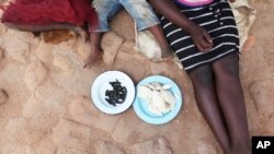 Une famille zimbabwéenne partage un repas devant leur domicile dans la localité de Gwanda le 7 janvier 2013. (AP Photo/Tsvangirayi Mukwazhi)