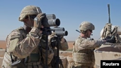 FILE - U.S. soldiers surveil the area during a combined joint patrol in Manbij, Syria, Nov. 1, 2018.