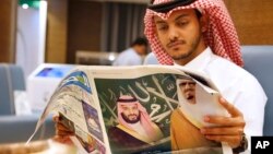 A man reads a newspaper with pictures of Saudi King Salman, right, and his Crown Prince Mohammed bin Salman, at the press center for the upcoming Arab and Islamic summits in Mecca, Saudi Arabia, May 30, 2019. 
