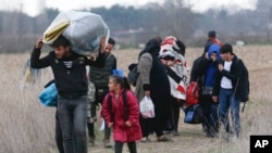 Para migran Suriah berjalan di Pazarkule, Turki dekat perbatasan dengan Yunani (foto: dok). 