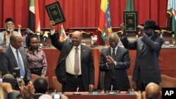 Sudan's President Omar al-Bashir, center-left, and South Sudan President Salva Kiir, right, celebrate the completion of a signing ceremony in Addis Ababa, Ethiopia, September 27, 2012.
