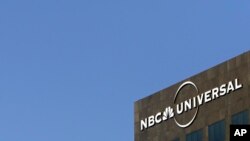 The NBC Universal logo hangs on a building in Los Angeles, Dec. 3, 2009. 