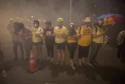 Members of the Wall of Moms protest group lock arms as they are tear-gassed by federal officers during a Black Lives Matter protest at the Mark O. Hatfield United States Courthouse, July 27, 2020, in Portland, Oregon.