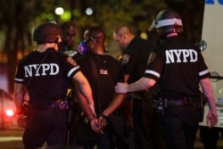 New York Police Department officers escort a protester after he was arrested at a rally calling for justice over the death of George Floyd, in the Brooklyn borough of New York, June 3, 2020.