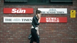 A woman speaks on her mobile phone outside the News International headquarters building in London