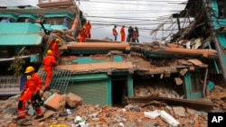 India's National Disaster Response Force personnel look for survivors in a building, in Kathmandu, Nepal, Sunday, April 26, 2015. (AP Photo/Manish Swarup)