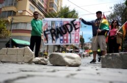 Demonstrators hold a sign reading "Fraud" in La Paz, Bolivia, Oct. 29, 2019.