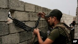 FILE - A soldier with the Iraqi special forces reloads his weapon on a rooftop in west Mosul as fighting between Iraqi troops and the Islamic State group continues, April 23, 2017.