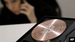 FILE - A Bitcoin logo is shown at a Bitcoin trading store, Dec. 21, 2017. 