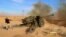 FILE - Syrian government troops fire at Islamic State group positions near Mahin, Syria, Jan. 30, 2016. Iran announced that it is bolstering its military presence in Syria.