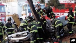 Les pompiers de Seattle s’activent à sortir des passagers d’un véhicule après un accident contre un arbre au Green Lake park à Seattle, Washington, 21 décembre 2006.