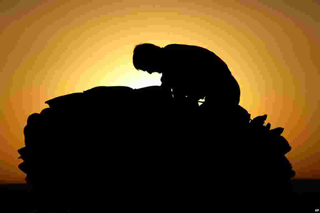 An Iraqi man, who fled the fighting between Iraqi forces and Islamic State militants, collects mattresses on the top of a pickup as he waits to cross to the Kurdish controlled area in the Nineveh plain, northeast of Mosul.