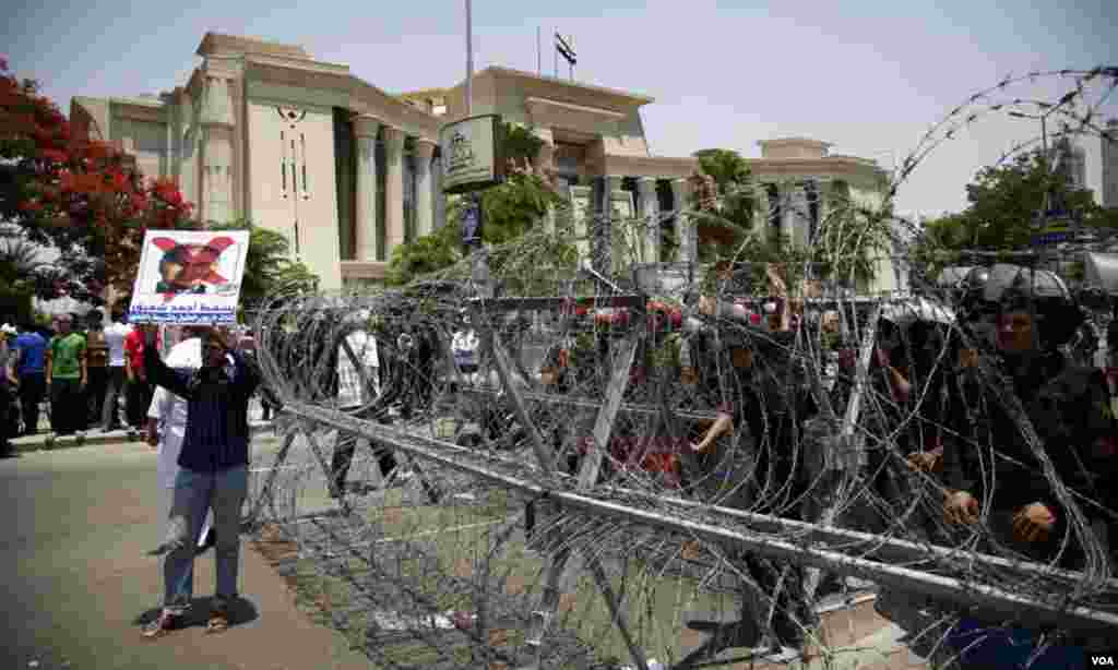 Protesters waved anti-Shafiq posters in front of rows of concertina wire, soldiers and police. (Y. Weeks for VOA)
