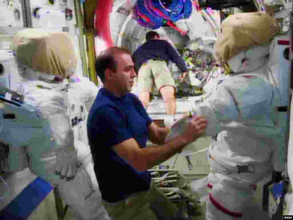 Astronot Rick Mastracchio (kiri) memeriksa baju yang akan ia pakai selama berjalan di luar angkasa bersama anggota tim NASA lainnya Michael Hopkins di Stasiun Antariksa Internasional. (Foto: NASA)