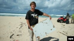 FILE - An undated handout photograph made available June 10, 2016, by Blaine Alain Gibson shows Gibson holding pieces of debris possibly belonging to the missing Malaysian Airlines plane MH370, which were found on Nosy Boraha island, Madagascar.