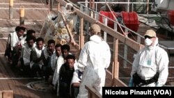 Migrants wait to disembark from the Norwegian ship Siem Pilot in Messina, Sicily, Italy, Oct. 6, 2015. (N. Pinault/VOA)