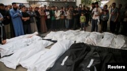 Ožalošćeni se mole i okupljaju u blizini tela Palestinaca ubijenih u izraelskim napadima, tokom njihove sahrane u Rafi, u južnom pojasu Gaze, 29. aprila 2024.