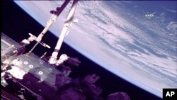 This photo provided by NASA shows astronauts Norishige Kanai of Japan, left, and NASA astronaut Mark Vande Hei during a spacewalk on the International Space Station on Friday, Feb. 16, 2018. 