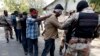 FILE - Paramilitary soldiers escort blindfolded men, who were detained during a raid on the Muttahida Qaumi Movement political party headquarters, after presenting them before an anti-terrorism court in Karachi, March 12, 2015.