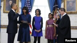 Presiden AS Barack Obama (kiri) saat diambil sumpahnya oleh Ketua Mahkamah Agung AS John Roberts disaksikan oleh ibu negara Michelle Obama dan kedua puterinya, Malia dan Sasha di Gedung Putih hari Minggu (20/1). 