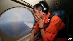 លោក Koji Kubota នៃកង​ឆ្មាំ​សមុទ្រ​ជប៉ុន​ពិនិត្យ​ផ្ទៃ​សមុទ្រ​ពី​លើ​យន្តហោះ​ក្នុង​អំឡុង​ការ​ហោះ​រុករក​បំណែក​យន្តហោះ​បាត់​ដាន MH370 កាល​ពី​ថ្ងៃ​ទី​១​ខែ​មេសា​ឆ្នាំ​២០១៤។