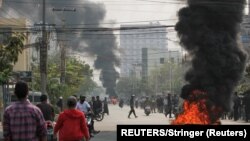 Myanmar, Mandalay, Tires burn on a street as protests against the military coup continue