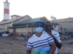 Naa Borkor and Emmanuel Quartey stand where their JayNii Streetwise Foundation once was, in James Town, May 29, 2020. (Stacey Knott/VOA)