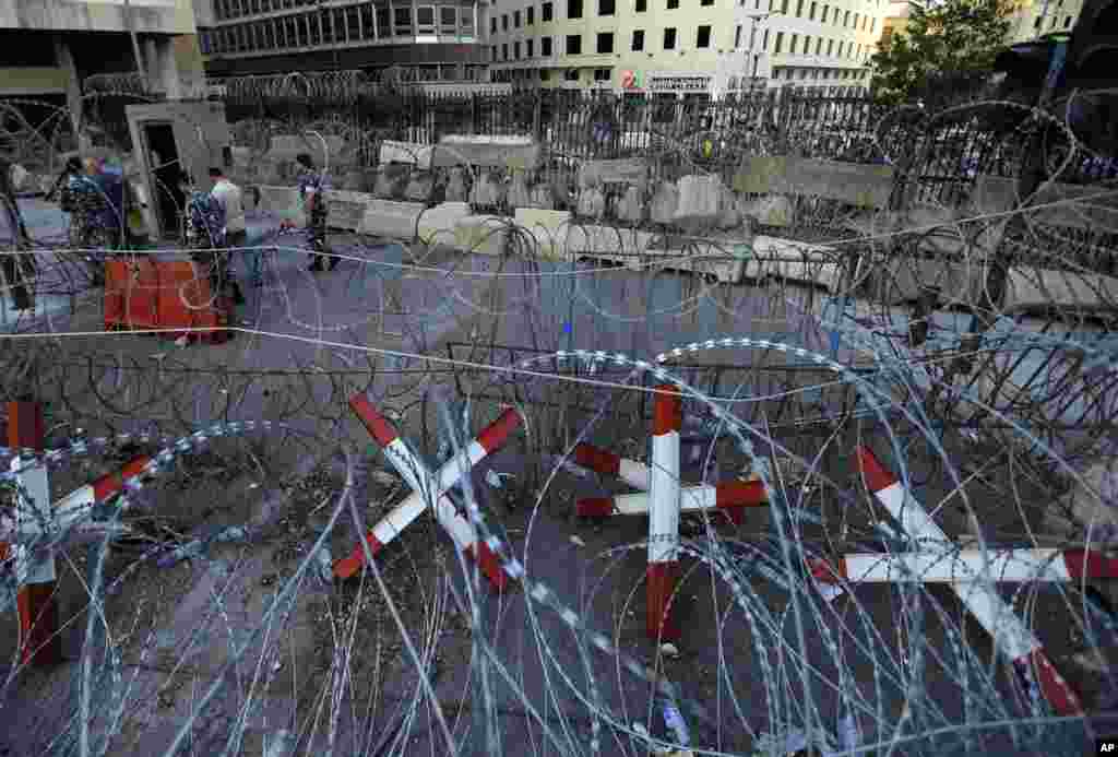 Lebanese policemen check metal barricades and other reinforcements that were installed as extra security measures around the Lebanese government building, in Beirut, Lebanon, Sept. 2, 2015.
