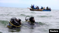 Des plongeurs recherchent d’éventuels survivants après le naufrage d’un bateau dans le lac Edourad Albert séparant la RDC et l’Ouganda, 23 mars 2014.