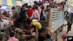 Cambodian migrant workers get off from a Thai truck upon their arrival from Thailand at a Cambodia-Thai international border gate in Poipet, Cambodia, Tuesday, June 17, 2014. 