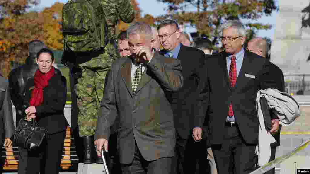 A man wipes a tear from his eye after paying his respects at the National War Memorial in downtown Ottawa, Oct. 23, 2014.