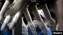 រូបឯកសារ៖ ក​ម្មករ​ប្រមូល​ស្រោម​ដៃ​នៅ​ឯ​រោង​ចក្រ​មួយ នៅ​ទីក្រុង​គូឡាឡាំពួ ប្រទេស​ម៉ាឡេស៊ី។