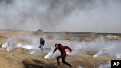 巴勒斯坦抗议者在加沙地带和以色列边界地区躲避以军发射的催泪瓦斯。（2018年4月13日）