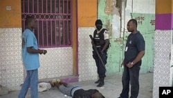 Police officers arrest a man outside the National Penitentiary during a prisoners' uprising in downtown Port-au-Prince, Haiti, 17 Oct 2010