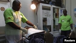 A doctor (L) performs circumcision on an unidentified politician in an effort to reduce the spread of HIV, in Harare, Zimbabwe, June 22, 2012.