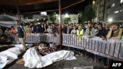 មនុស្សផ្តុំគ្នាជុំវិញសាកសពជនជាតិប៉ាឡេស្ទីនដែលត្រូវបានសម្លាប់នៅក្នុងការវាយប្រហារតាមអាកាសរបស់អ៊ីស្រាអែលទៅលើមន្ទីរពេទ្យ Ahli Arab នៅកណ្តាលហ្គាហ្សា បន្ទាប់ពីពួកគេត្រូវបានបញ្ជូនទៅមន្ទីរពេទ្យ Al-Shifa នៅថ្ងៃទី១៧ ខែតុលា ឆ្នាំ២០២៣។