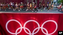 Runners compete in the women's marathon at the 2020 Summer Olympics, Aug. 7, 2021, in Sapporo, Japan.